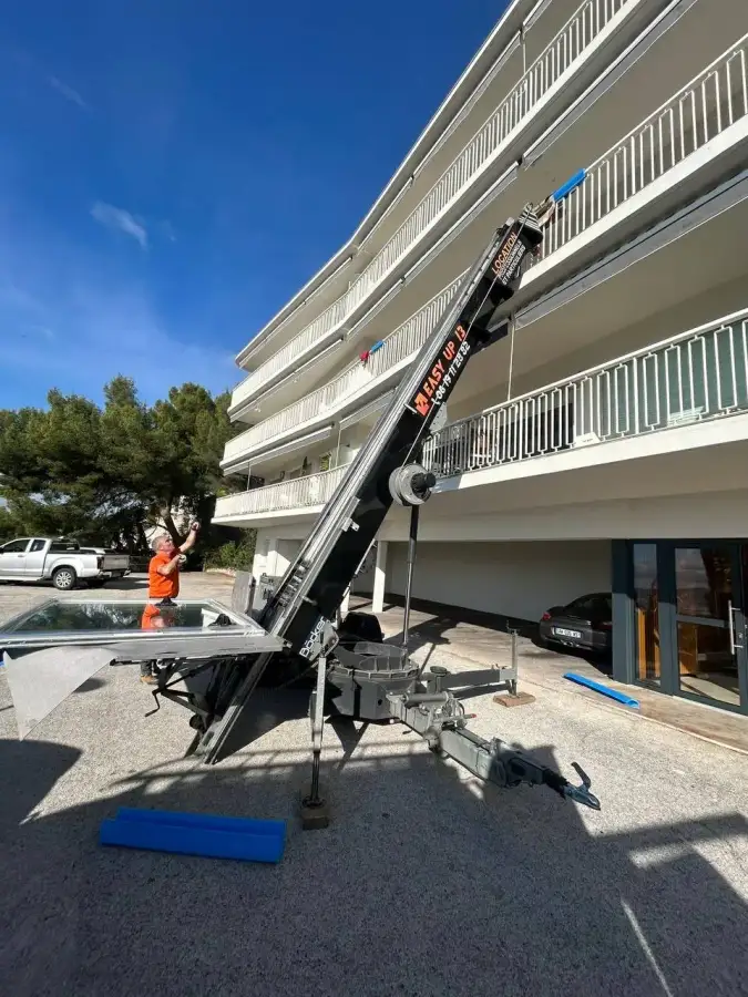 Pose d'une grande baie vitrée sur un chantier